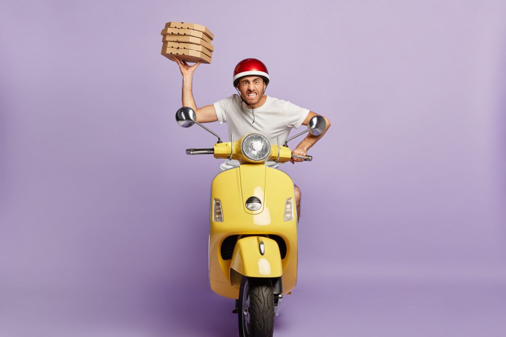impatient-deliveryman-driving-scooter-while-holding-pizza-boxes
